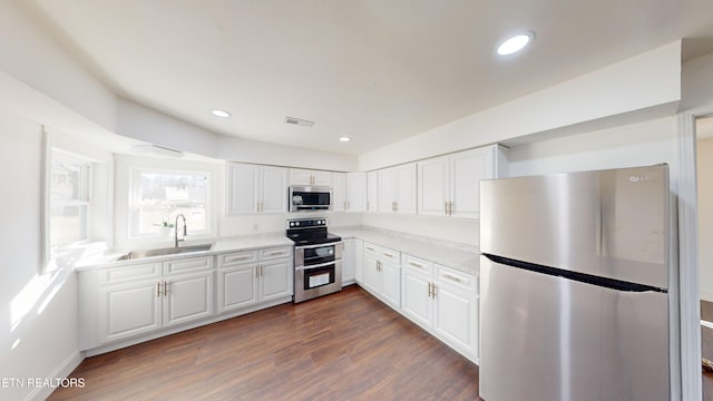 kitchen featuring dark hardwood / wood-style flooring, sink, white cabinets, and appliances with stainless steel finishes