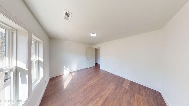 unfurnished room with dark wood-type flooring