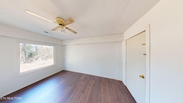 empty room featuring dark hardwood / wood-style flooring and ceiling fan