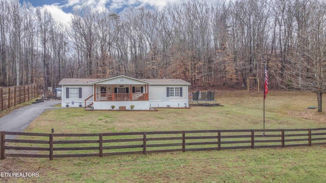 view of front of property featuring a front yard, a trampoline, and covered porch