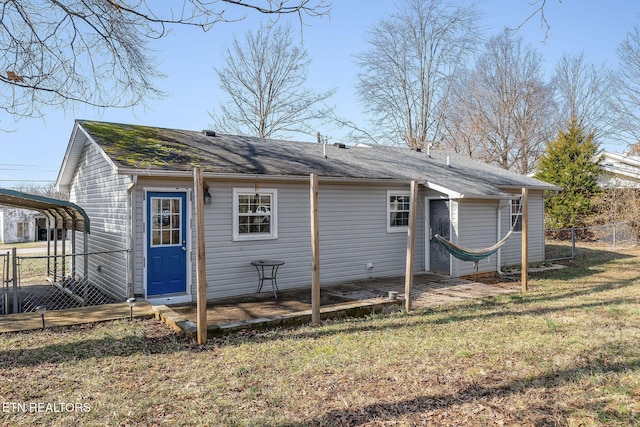 back of property featuring a lawn and a carport