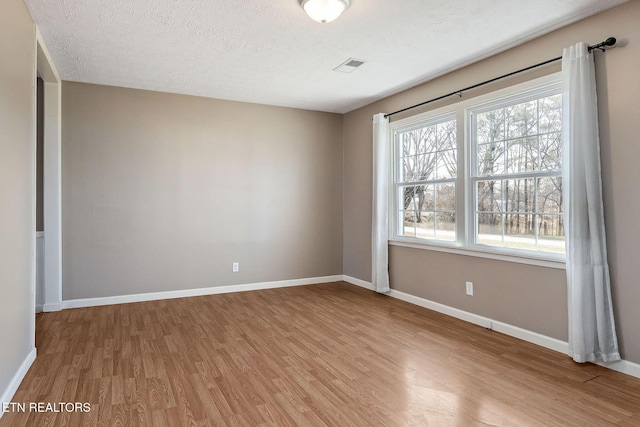 spare room with hardwood / wood-style floors and a textured ceiling