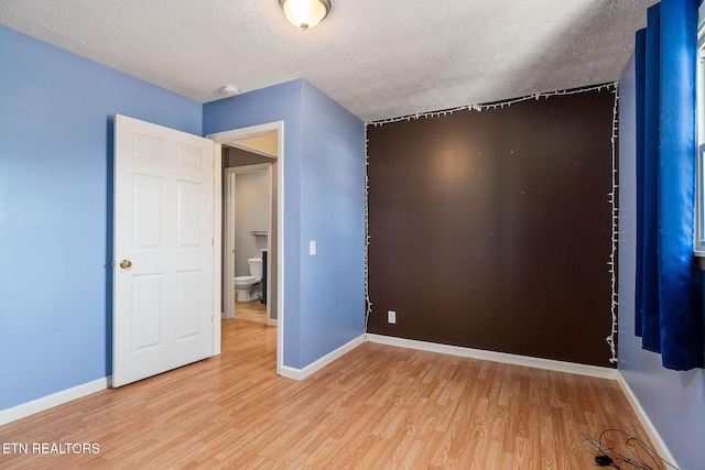 unfurnished bedroom featuring hardwood / wood-style floors and a textured ceiling