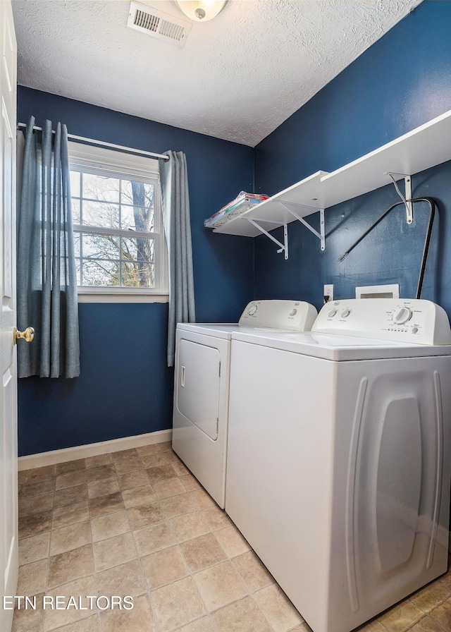 washroom with washing machine and clothes dryer and a textured ceiling