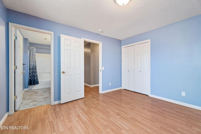 unfurnished bedroom with a closet, a textured ceiling, and light wood-type flooring