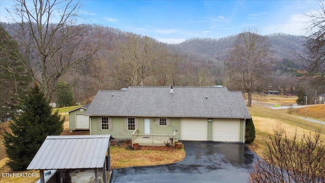 rear view of property featuring a garage and a mountain view