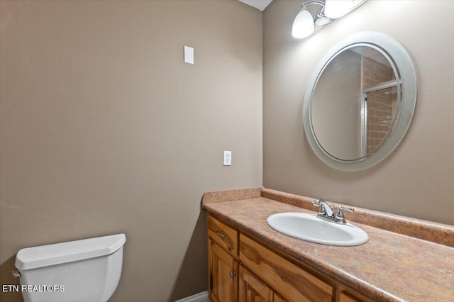 bathroom featuring vanity, a shower, and toilet