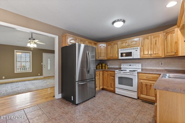 kitchen featuring sink, tasteful backsplash, light tile patterned floors, ceiling fan, and white appliances