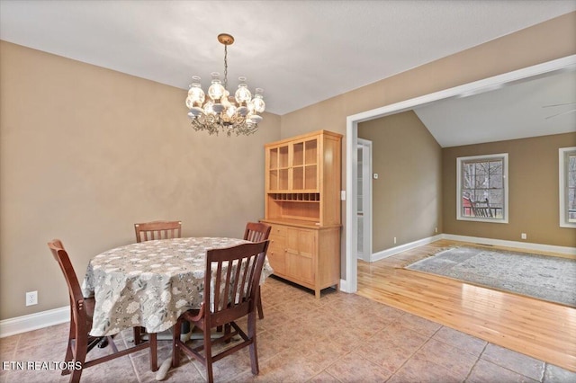 dining room with vaulted ceiling, a chandelier, and light hardwood / wood-style floors