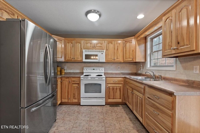 kitchen with light tile patterned flooring, white appliances, sink, and backsplash