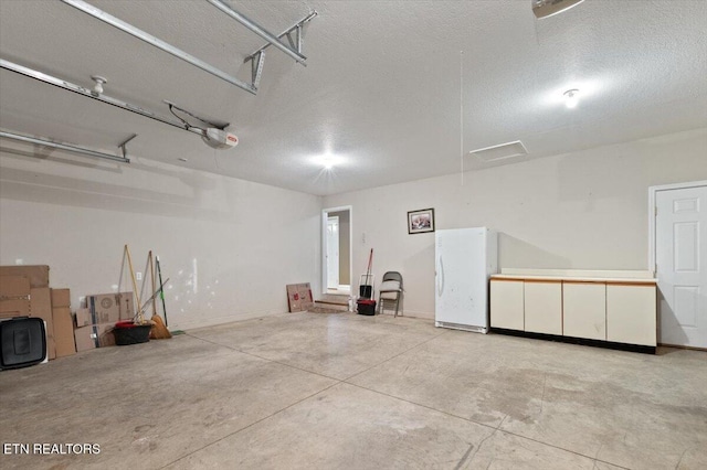 142 Wagon Wheel Ln, Pioneer, TN 37847 - garage with freestanding refrigerator and a garage door opener