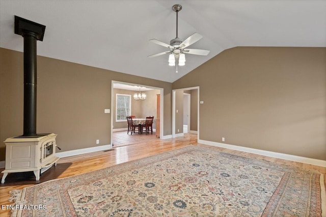 142 Wagon Wheel Ln, Pioneer, TN 37847 - unfurnished living room featuring ceiling fan, a chandelier, wood finished floors, a wood stove, and vaulted ceiling