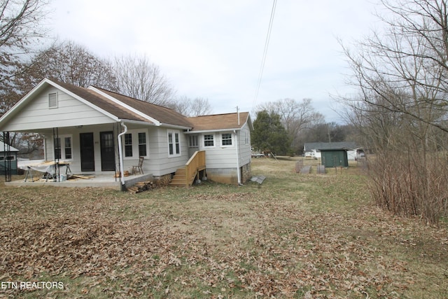 back of property featuring a patio and a storage shed