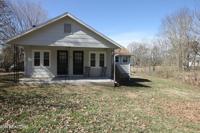 rear view of property with a yard