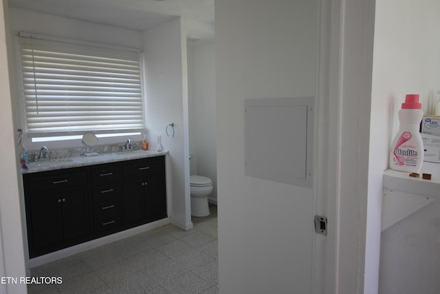 full bath with double vanity, a sink, toilet, and tile patterned floors