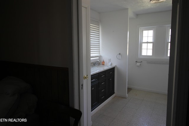 bathroom with vanity, baseboards, a textured ceiling, and tile patterned floors