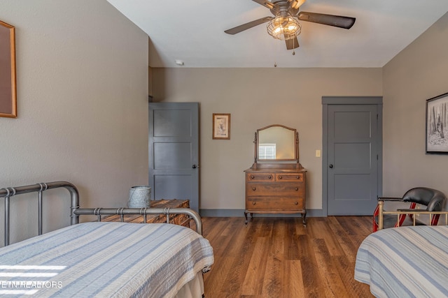 bedroom with dark hardwood / wood-style flooring and ceiling fan