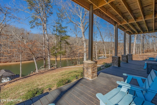 deck featuring a water view and a lawn