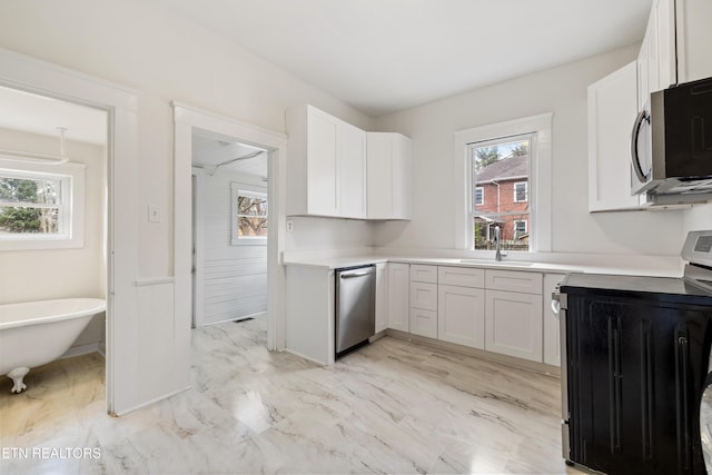 112 E Inskip Dr, Knoxville, TN 37912 - kitchen with appliances with stainless steel finishes, a sink, white cabinetry, light countertops, and light marble finish floors