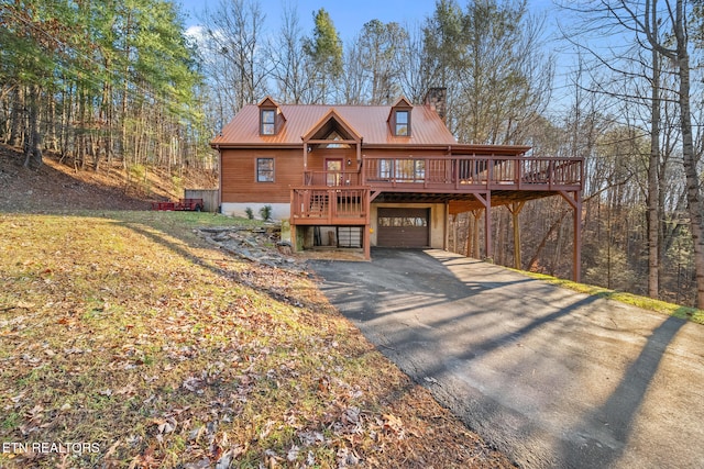 log cabin featuring a garage and a wooden deck