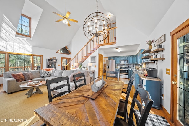 dining room with sink, light hardwood / wood-style flooring, high vaulted ceiling, and ceiling fan