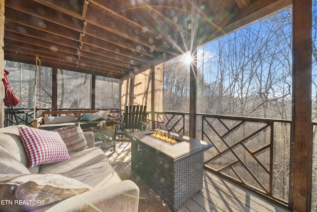 deck featuring an outdoor living space with a fire pit