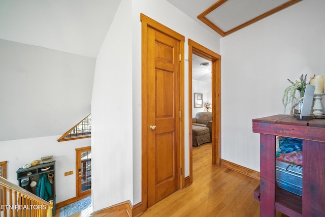 hallway featuring vaulted ceiling and light wood-type flooring