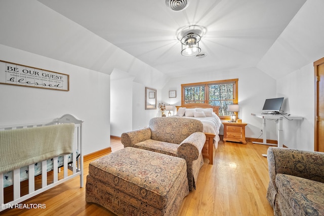 bedroom featuring lofted ceiling and light wood-type flooring