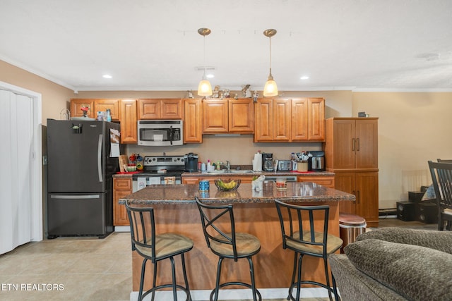 kitchen with ornamental molding, appliances with stainless steel finishes, a center island, and hanging light fixtures