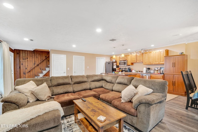 living room featuring light hardwood / wood-style flooring and wooden walls