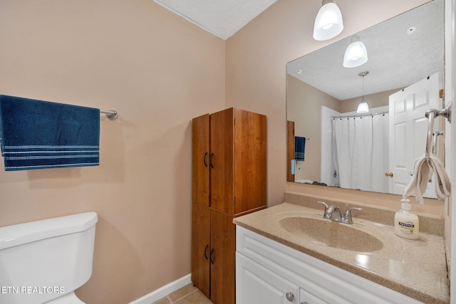 bathroom featuring vanity, a textured ceiling, tile patterned floors, toilet, and walk in shower