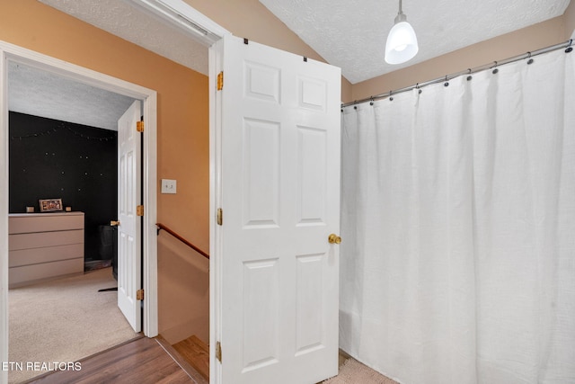 bathroom with hardwood / wood-style floors and a textured ceiling