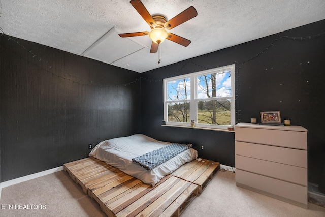 carpeted bedroom featuring ceiling fan and a textured ceiling