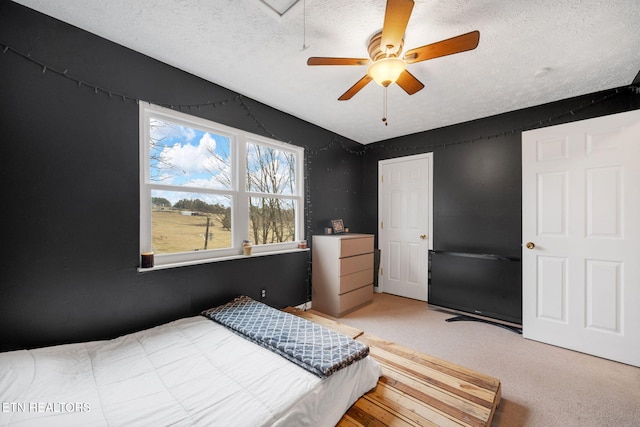 carpeted bedroom with ceiling fan and a textured ceiling