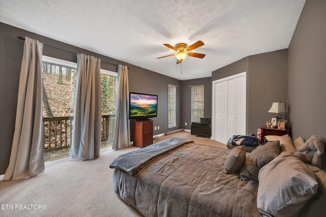 bedroom featuring access to exterior, light colored carpet, and a textured ceiling