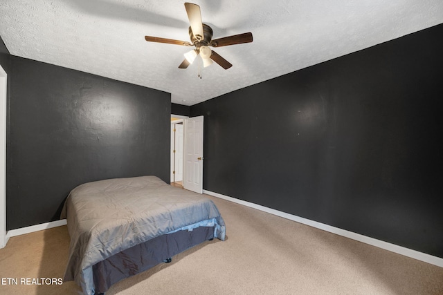 carpeted bedroom featuring ceiling fan and a textured ceiling