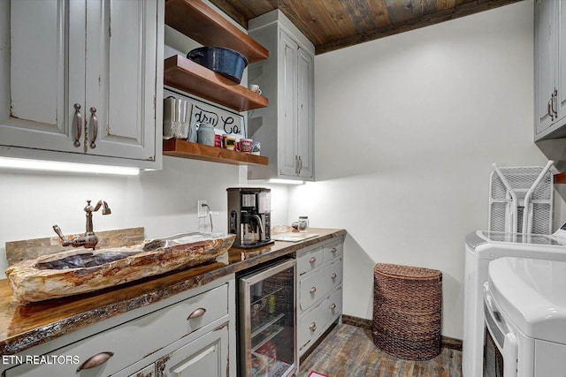 kitchen with sink, washer and dryer, wooden ceiling, gray cabinets, and beverage cooler