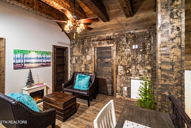 unfurnished room with wood-type flooring, wooden ceiling, lofted ceiling with beams, and ceiling fan