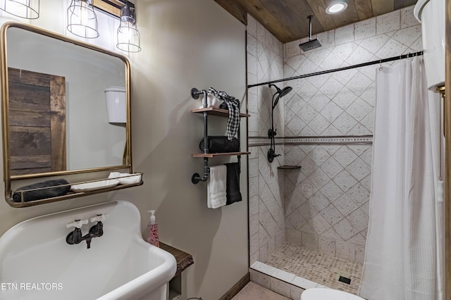 bathroom with sink, curtained shower, and toilet