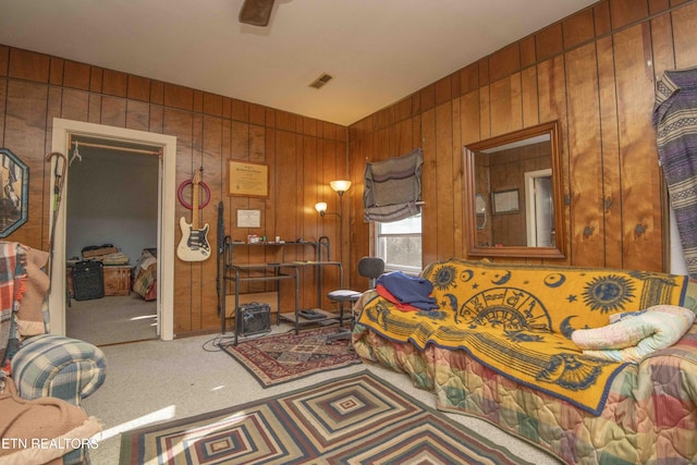 carpeted bedroom with wood walls