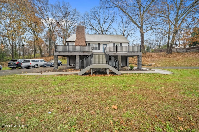 rear view of house with a yard and a deck