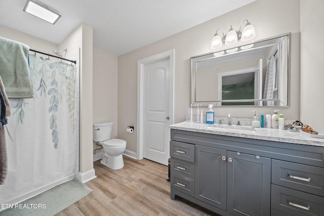 bathroom featuring vanity, hardwood / wood-style floors, a shower with curtain, and toilet