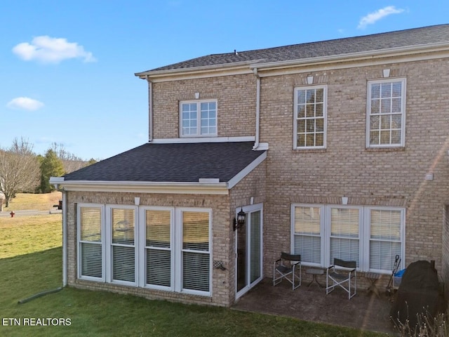 rear view of property with a yard and a patio area