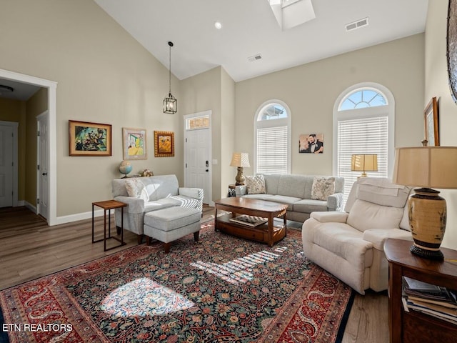 living room featuring hardwood / wood-style flooring and high vaulted ceiling