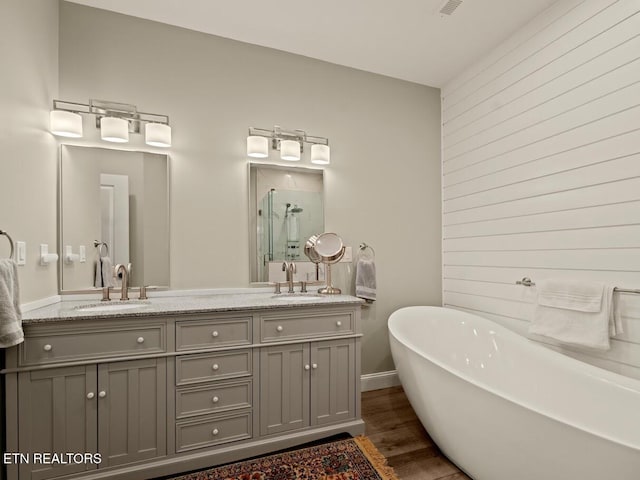 bathroom featuring vanity, hardwood / wood-style floors, and plus walk in shower