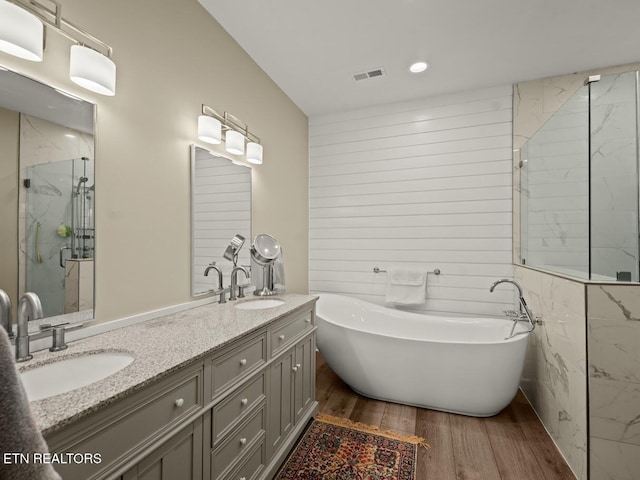 bathroom with vanity, hardwood / wood-style flooring, and shower with separate bathtub