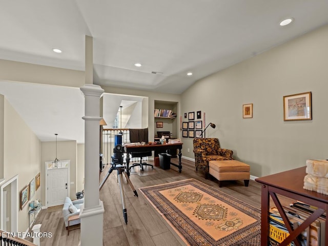 office area with hardwood / wood-style flooring, vaulted ceiling, and ornate columns