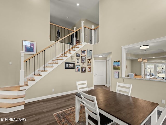 dining room with a notable chandelier, dark hardwood / wood-style floors, and a high ceiling