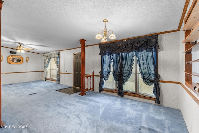 spare room with carpet, ceiling fan with notable chandelier, and a textured ceiling