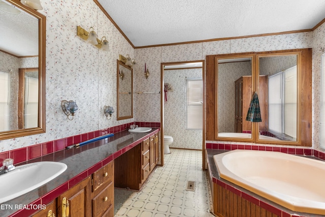 bathroom with ornamental molding, vanity, and toilet